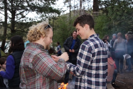 Liam presenting a braided cedar bracelet to a graduating ambassador.